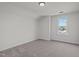 Minimalist bedroom with neutral carpet and paint, complemented by natural light through the window at 2015 Cheek Rd, Durham, NC 27704