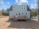 Rear view of the blue two-story home with a brand-new wooden deck and back yard at 2015 Cheek Rd, Durham, NC 27704