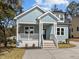 Inviting light blue home with a cozy porch, wooden stairs, and a black front door at 2015 Cheek Rd, Durham, NC 27704