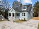 Light blue exterior of the house featuring a welcoming front porch and meticulously landscaped yard at 2015 Cheek Rd, Durham, NC 27704