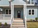 Inviting front porch with classic white railings and steps, complemented by fresh landscaping at 2015 Cheek Rd, Durham, NC 27704