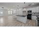 Modern kitchen with a center island and sleek black appliances, open to the living area at 2015 Cheek Rd, Durham, NC 27704
