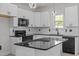 Modern kitchen featuring white cabinets, black countertops, and stainless steel appliances at 2015 Cheek Rd, Durham, NC 27704