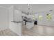 Open kitchen featuring black countertops, white cabinets, modern light fixtures, and stainless appliances at 2015 Cheek Rd, Durham, NC 27704