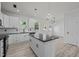 Modern kitchen with white cabinets, stainless appliances, black countertops, and wood-look flooring at 2015 Cheek Rd, Durham, NC 27704