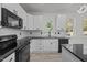 Well-lit kitchen featuring white cabinets, black counters, and stainless steel appliances at 2015 Cheek Rd, Durham, NC 27704