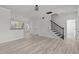 Spacious living room featuring light wood floors, a staircase, and fresh neutral paint at 2015 Cheek Rd, Durham, NC 27704