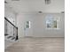Bright living room features light wood floors, a staircase, and a modern light fixture at 2015 Cheek Rd, Durham, NC 27704