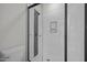 Modern shower with black trim, white tile, mosaic accent stripe, and a frameless glass door at 2015 Cheek Rd, Durham, NC 27704