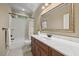 Well-lit bathroom featuring a granite vanity, framed mirror, and a shower-tub combination with tile surround at 208 Bellagio Dr, Apex, NC 27539