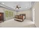 Primary bedroom featuring tray ceilings, neutral paint and carpet, and large windows at 208 Bellagio Dr, Apex, NC 27539