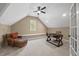 Upstairs bonus room featuring sloped ceilings, natural light, and built-in shelving at 208 Bellagio Dr, Apex, NC 27539