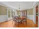 Elegant dining room featuring a large window, hardwood floors, and decorative lighting fixture at 208 Bellagio Dr, Apex, NC 27539
