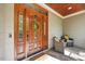 Inviting front porch with comfortable seating, a wooden front door with decorative wreath, and neutral-toned decor at 208 Bellagio Dr, Apex, NC 27539