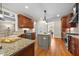 Gourmet kitchen featuring granite countertops, stainless appliances, and custom wood cabinetry with island at 208 Bellagio Dr, Apex, NC 27539