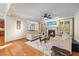 Cozy living room with a fireplace, plush sofas, and views into the kitchen and backyard at 208 Bellagio Dr, Apex, NC 27539