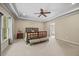 Spacious primary bedroom with a tray ceiling, a ceiling fan, and large windows offering natural light at 208 Bellagio Dr, Apex, NC 27539