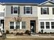 A two-story townhome features a brick and vinyl exterior with dark shutters and newly planted landscaping at 2107 Glen Crossing Dr, Durham, NC 27704
