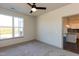 Empty bedroom featuring carpet flooring, a window with a view of outdoors, and a doorway to the kitchen at 2205 Gathering Square Ct, Fuquay Varina, NC 27526