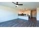 Spacious living area featuring hard surface floors, ceiling fan, and an open kitchen concept at 2205 Gathering Square Ct, Fuquay Varina, NC 27526