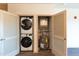 Stacked washer and dryer with shelving in utility closet at 2205 Gathering Square Ct, Fuquay Varina, NC 27526