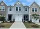 Charming townhome featuring a clean driveway, white garage, and complementary landscape for an inviting curb appeal at 247 Paramount Dr # 104, Smithfield, NC 27577