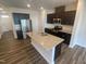 Kitchen showcases stainless steel appliances, a kitchen island sink, dark wooden cabinets and granite countertops at 247 Paramount Dr # 104, Smithfield, NC 27577