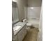 Bathroom features granite counters, white vanity, toilet, and shower-over-tub with white surround at 284 Irvan St, Clayton, NC 27520