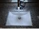 Close-up of a bathroom sink with granite countertop and modern faucet with running water at 284 Irvan St, Clayton, NC 27520