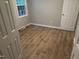 Bedroom featuring wood-look floors and fresh paint, illuminated by natural light from the window at 284 Irvan St, Clayton, NC 27520