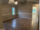 Spacious living room features wood-look flooring, a ceiling fan, and access to other rooms at 284 Irvan St, Clayton, NC 27520