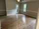 Open-concept living room with wood-look flooring, ceiling fan, and sliding glass door to the exterior at 284 Irvan St, Clayton, NC 27520