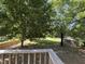 Private backyard with mature trees, partial fencing, and a serene, shaded lawn at 304 Culvert St, Apex, NC 27502