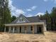 Charming one-story home with a covered front porch and light gray siding, nestled in a wooded lot at 328 Green Pines Estates Dr, Kenly, NC 27542