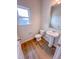 Powder room featuring wood-look floors, a pedestal sink, and a bright window at 355 Beacon Hill Rd # 23, Lillington, NC 27546