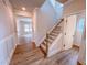 Hallway with wood-look floors, featuring a staircase and multiple doorways at 355 Beacon Hill Rd # 23, Lillington, NC 27546