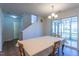 Bright dining area with a white table, light-colored chairs, and a sliding glass door leading to an outdoor space at 3629 Brittlebank Dr, Raleigh, NC 27610