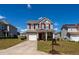 Inviting two-story home showcasing a well-manicured lawn, red shutters, and an attached front garage at 3629 Brittlebank Dr, Raleigh, NC 27610