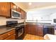 Well-lit kitchen featuring wooden cabinets and black appliances, including a range and microwave at 3629 Brittlebank Dr, Raleigh, NC 27610