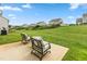Cozy backyard with two chairs on a concrete patio and a grassy area at 3832 Stovall Dr, Haw River, NC 27258