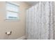 This bathroom features a shower with a curtain, a window, and a toilet paper holder at 3832 Stovall Dr, Haw River, NC 27258