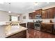 A kitchen featuring dark cabinets, stainless steel appliances, granite countertops, and hardwood floors at 3832 Stovall Dr, Haw River, NC 27258