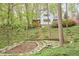 Spacious backyard with terraced landscaping and stone pathways leading to the white home with a covered porch at 4 The Gln, Chapel Hill, NC 27514