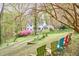 Beautiful backyard with Adirondack chairs arranged for relaxing under trees at 4 The Gln, Chapel Hill, NC 27514