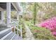 Stone pathway leading to a lush backyard, surrounded by azaleas and mature trees at 4 The Gln, Chapel Hill, NC 27514