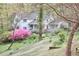 Charming white house with a covered front porch, surrounded by lush landscaping and flowering trees at 4 The Gln, Chapel Hill, NC 27514
