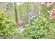 Home exterior featuring flowering shrubs and trees amid a lush, verdant landscape at 4 The Gln, Chapel Hill, NC 27514