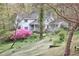 Charming white house with a covered front porch, surrounded by lush landscaping and flowering trees at 4 The Gln, Chapel Hill, NC 27514