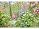 Home exterior featuring flowering shrubs and trees amid a lush, verdant landscape at 4 The Gln, Chapel Hill, NC 27514