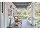 Relaxing covered porch with rocking chair, offering views of the serene, landscaped yard and lush greenery at 4 The Gln, Chapel Hill, NC 27514